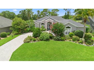 Charming single-story home with mature landscaping, lush green lawn and a patterned brick driveway at 856 Bentley Green Cir, Winter Springs, FL 32708