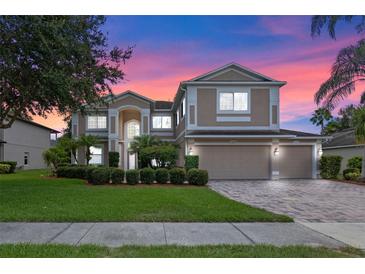 Elegant two-story home boasts a manicured lawn, mature landscaping, and a three-car garage, perfect for Gathering living at 1097 Harmony Ln, Clermont, FL 34711