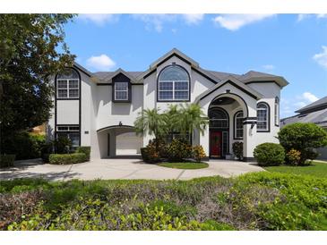 Stunning two-story home featuring black trim, a circular driveway, and a portico garage entrance at 1741 Edgewater Dr, Mount Dora, FL 32757
