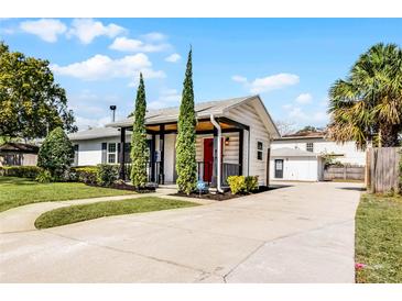 Charming one-story home featuring a bright red door and well-manicured front yard at 1911 Canton St, Orlando, FL 32803