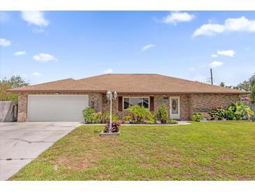 Charming single-story brick home featuring a well-maintained lawn and beautiful landscaping at 2098 Heathwood St, Deltona, FL 32725