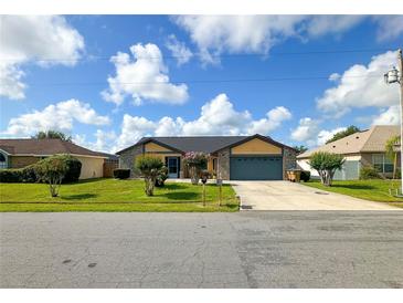 Charming single-Gathering home featuring a two-car garage and manicured front lawn with colorful bushes at 22 Bradford Ct, Kissimmee, FL 34758