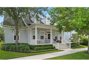 Charming home with a covered front porch, white columns, manicured landscaping, and mature trees at 2781 Stanfield Ave, Orlando, FL 32814