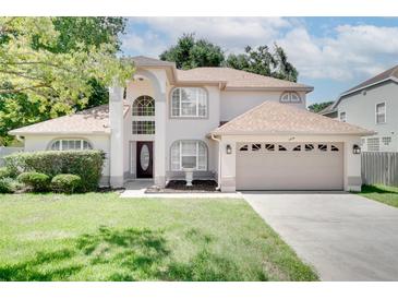 Charming two-story home featuring a well-maintained lawn and a two-car garage at 3519 Gatlin Place Cir, Orlando, FL 32812
