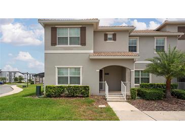 Charming townhome with a well-manicured lawn and inviting front entrance, perfect for a growing Gathering at 4974 Windermere Ave, Kissimmee, FL 34746