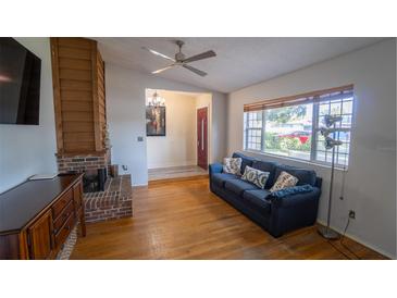 Inviting living room with a fireplace, hardwood floors, and a comfortable blue sofa at 901 Candle Berry Rd, Orlando, FL 32825