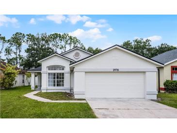 Charming single-Gathering home featuring a well-maintained lawn, two-car garage, and inviting front entrance at 2978 Stillwater Dr, Kissimmee, FL 34743