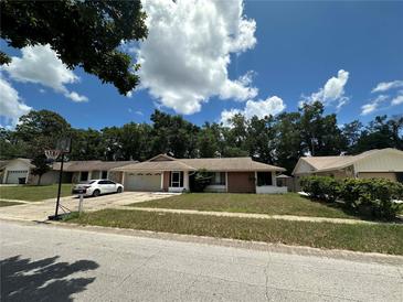 Charming single-story home featuring a well-kept lawn, attached garage, and a basketball hoop in the driveway at 448 S Meander Dr, Altamonte Springs, FL 32714