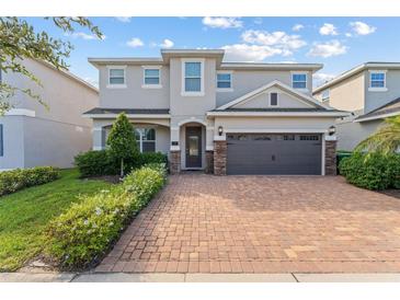 Beautiful two-story home with a brick driveway and a well-manicured front lawn at 7456 Marker Ave, Kissimmee, FL 34747