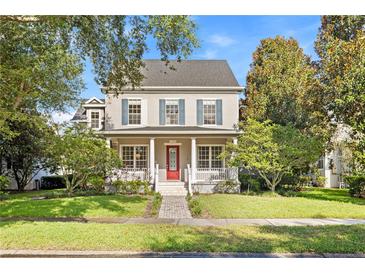 Charming two-story home featuring a inviting front porch, well-manicured lawn and mature trees at 11333 Camden Park Dr, Windermere, FL 34786