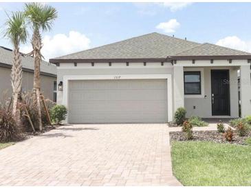 Beautiful single-Gathering home boasts a brick paved driveway and a neutral gray exterior at 1328 Lombardi Ct, Poinciana, FL 34759
