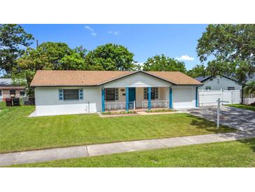 Charming single-story home featuring a well-maintained lawn, and a quaint front porch with blue accents at 1328 S Oxalis Ave, Orlando, FL 32807