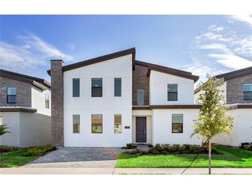 Contemporary two-story home with a modern design, featuring sleek lines, a stone accent wall, and well-manicured landscaping at 2907 Fable St, Kissimmee, FL 34746