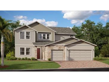 Two-story home with stone accents, a two-car garage, and lush landscaping, offering curb appeal at 326 Puma Loop, Groveland, FL 34736