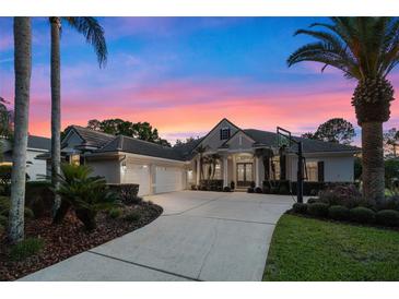 Stunning home exterior with a well-manicured lawn, mature palm trees, and a circular driveway at sunset at 3267 Regal Crest Dr, Longwood, FL 32779