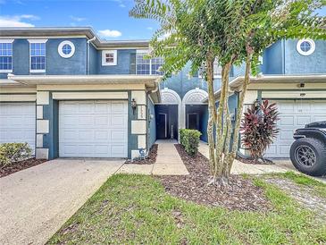 Charming townhouse exterior with a two-car garage, arched entry, and well-maintained landscaping at 3559 Victoria Pines Dr # 280, Orlando, FL 32829