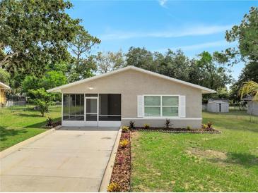 Charming single-story home featuring a screened porch, well-maintained lawn, and tidy landscaping at 458 Spring Ln, Ocala, FL 34472
