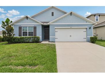 Charming single-story home with a well-manicured lawn and a two-car garage at 585 Talisi Loop, St Cloud, FL 34771