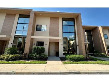 Modern two-story townhome featuring large windows and manicured landscaping in a desirable community at 7528 Brooklyn Dr, Kissimmee, FL 34747