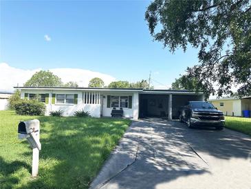 Charming single-story home with a long driveway and attached carport, perfect for a convenient lifestyle at 107 Dellwood Dr, Kissimmee, FL 34744