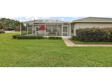 Enjoy outdoor living on this screened patio with views of the manicured lawn and lush landscaping at 1105 Apple Ter, Leesburg, FL 34748