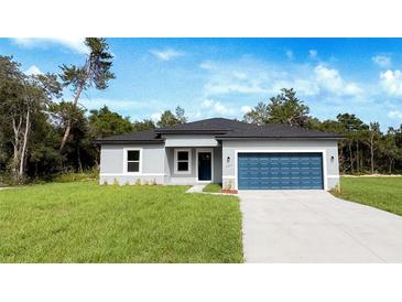 Charming single-story home features a well-manicured lawn and a blue two-car garage at 15625 Sw 37Th Cir, Ocala, FL 34473