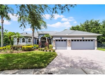 Charming single-story home with a manicured lawn, mature landscaping, and a three-car garage at 1640 Wild Indigo Ter, Oviedo, FL 32766