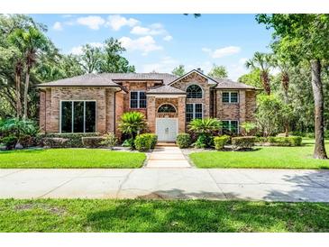 Beautiful brick home featuring a meticulously maintained lawn and mature landscaping at 1717 Fountainhead Dr, Lake Mary, FL 32746