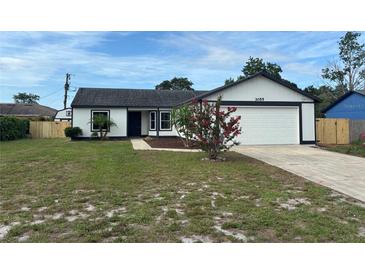 Charming single-story home with a well-maintained lawn and an attached two car garage at 3055 Kirkland St, Deltona, FL 32738