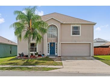Charming two-story home featuring a well-maintained lawn, a large palm tree, and a two-car garage at 328 Fairfield Dr, Sanford, FL 32771