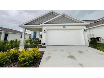 Charming home with a two-car garage, blue door, and tastefully landscaped front yard at 4295 Twisted Twig Bnd, Kissimmee, FL 34746