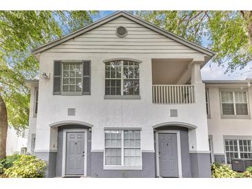Charming condo featuring a white stucco exterior, gray accents, and a cozy second-story balcony at 4356 S Kirkman Rd # 514, Orlando, FL 32811