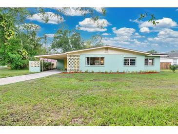 Charming vintage home featuring a well-manicured lawn, carport, and quaint curb appeal at 1210 S Palmetto Ave, Sanford, FL 32771