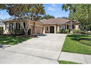 Well-maintained single-story home with a spacious driveway and a manicured lawn at 13943 Caywood Pond Dr, Windermere, FL 34786