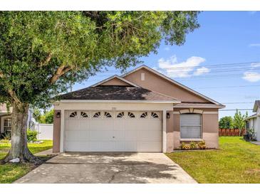 Tan single-Gathering home with a two-car garage and a well-manicured lawn at 2181 Jessa Dr, Kissimmee, FL 34743
