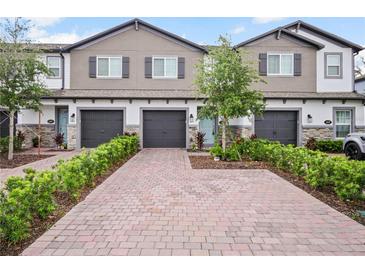 Beautiful townhomes featuring brick driveways, attached garages and manicured landscaping at 463 Cape Honeysuckle Pl, Sanford, FL 32771