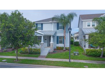 Charming two-story home featuring manicured landscaping, a covered porch, and a neatly maintained lawn at 9069 Pinch Shot Dr, Winter Garden, FL 34787