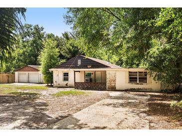Exterior front view of a single-story home with a yard and a detached garage at 9536 Peer Dr, Orlando, FL 32817