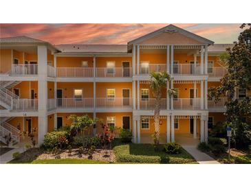 Brightly painted condo building with white railings and lush landscaping shows inviting facade at 1109 New Providence # 141109, Davenport, FL 33897