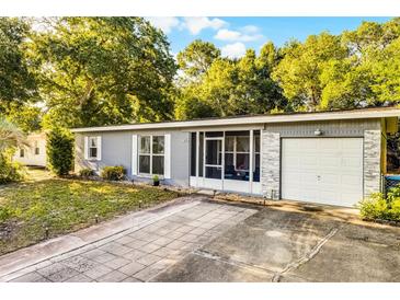 Charming single-story home featuring a screened porch, garage and a tidy front yard with a concrete tile driveway at 1649 Weybridge St, Deltona, FL 32725