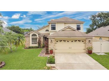 Charming two-story home features a brick facade, well-manicured lawn, and attached two car garage at 1916 Excalibur Dr, Orlando, FL 32822