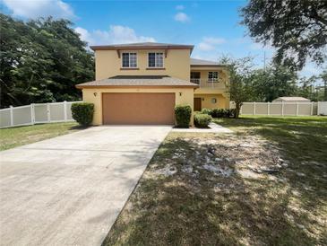 Two-story home with a two car garage, balcony, and well manicured lawn with a blue sky at 281 Covent Gardens Pl, Deltona, FL 32725