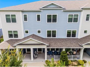 Three-story townhouse featuring a covered front porch, blue siding, and white trim at 461 Diamond Dove Cv, Winter Springs, FL 32708