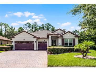 Beautiful single-story home with a three-car garage, well-manicured lawn and charming landscaping at 100 Verde Way, Debary, FL 32713
