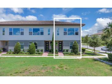Inviting two-story home with a well-manicured lawn, lush landscaping, and a charming brick pathway leading to the front door at 10120 Sunnifa Aly, Orlando, FL 32832