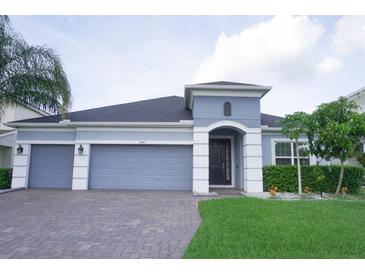Charming single-story home with a three-car garage and well-maintained landscaping at 14146 Jomatt Loop, Winter Garden, FL 34787