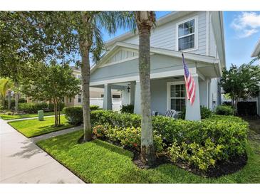 Charming two-story home featuring a cozy front porch, manicured lawn, and vibrant landscaping at 16262 Firedragon Dr, Winter Garden, FL 34787