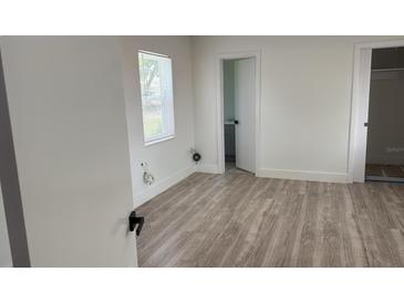 Bright bedroom with gray flooring, white walls, and a window with natural light at 311 Osceola Ave, Lake Wales, FL 33853