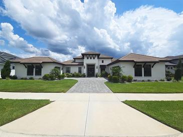 Stunning single-story home featuring a tile roof, manicured lawn, and inviting walkway leading to a grand entrance at 4073 Juliana Lake Dr, Auburndale, FL 33823
