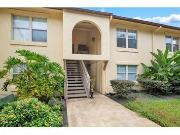 Condo exterior with plants, grassy areas, wooden steps and an arched entry way at 754 E Michigan St # 182, Orlando, FL 32806